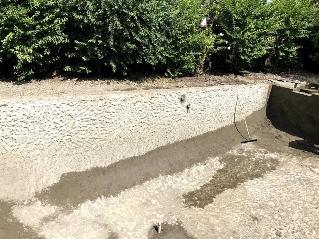 A swimming pool is being built in a backyard.